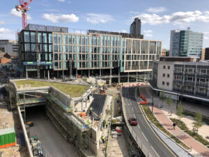 A blue roof provides a drainage system within the green roof system